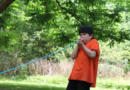 A child using a speaking into a rope. 
