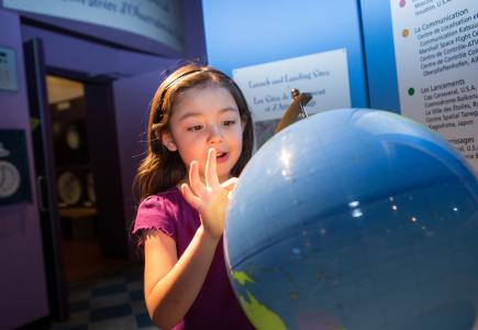 girl pointing at globe