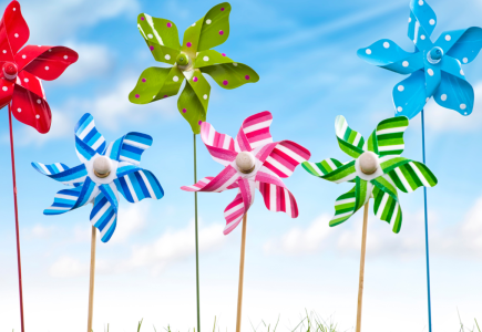 Colourful pinwheels with the sky in background.