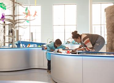 Child and caregiver play at water table