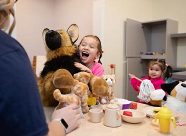Child with stuffy in Community roots exhibit
